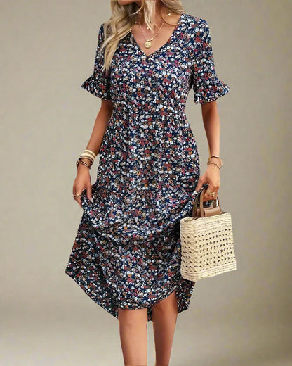 Woman wearing a floral dress holding a straw bag on a white background